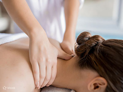 woman massaging the shoulders of a woman